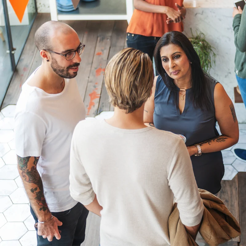 Grupo de personas conversando de pie en un taller.