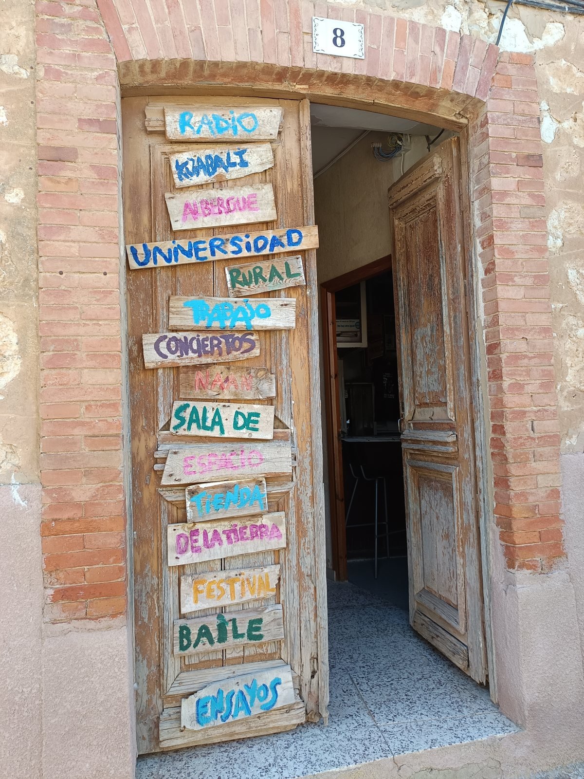 Puerta de la Universidad Rural del Cerrato con sus carteles pintados a mano