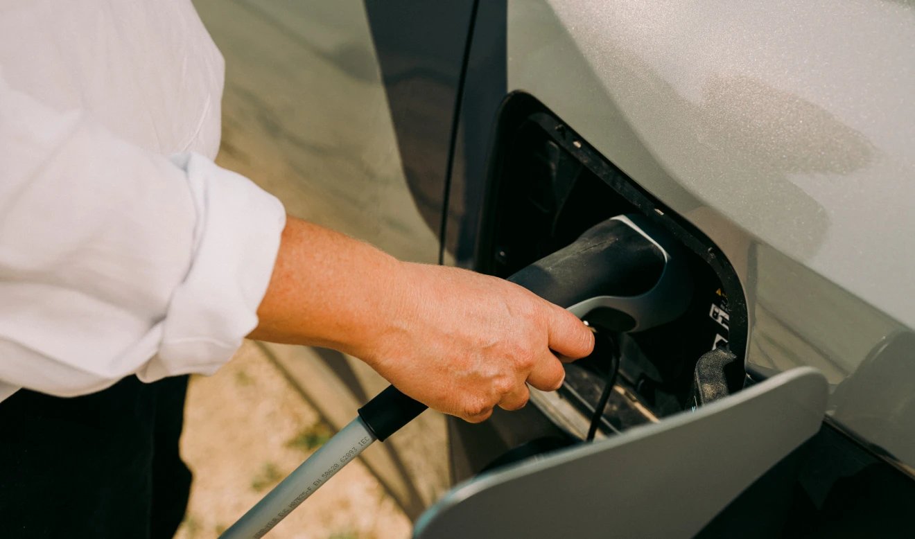 Persona cargando coche eléctrico